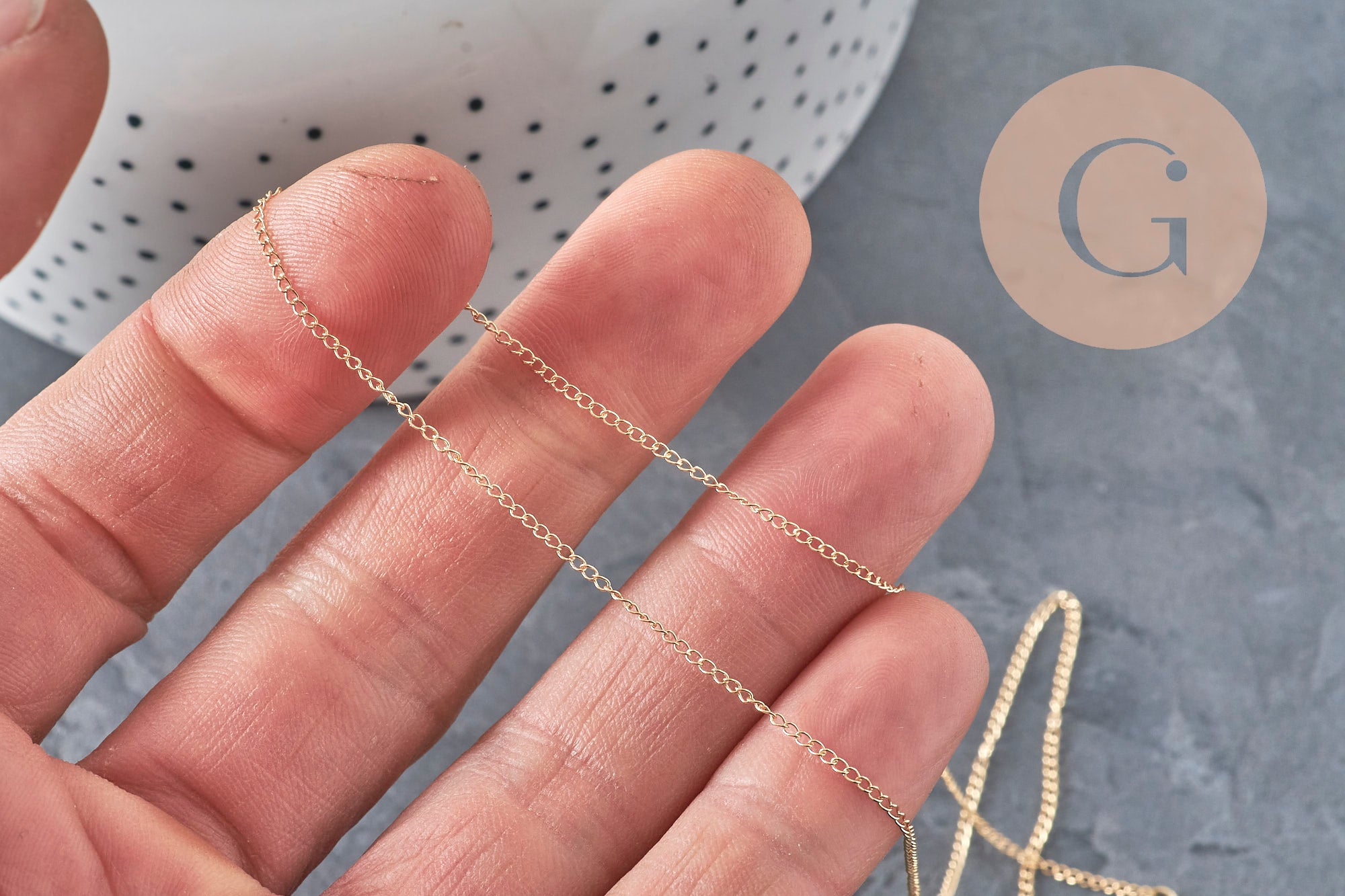Collier chaîne fine dorée gold-filled 14K de 45.7cm, tenue à la main.
