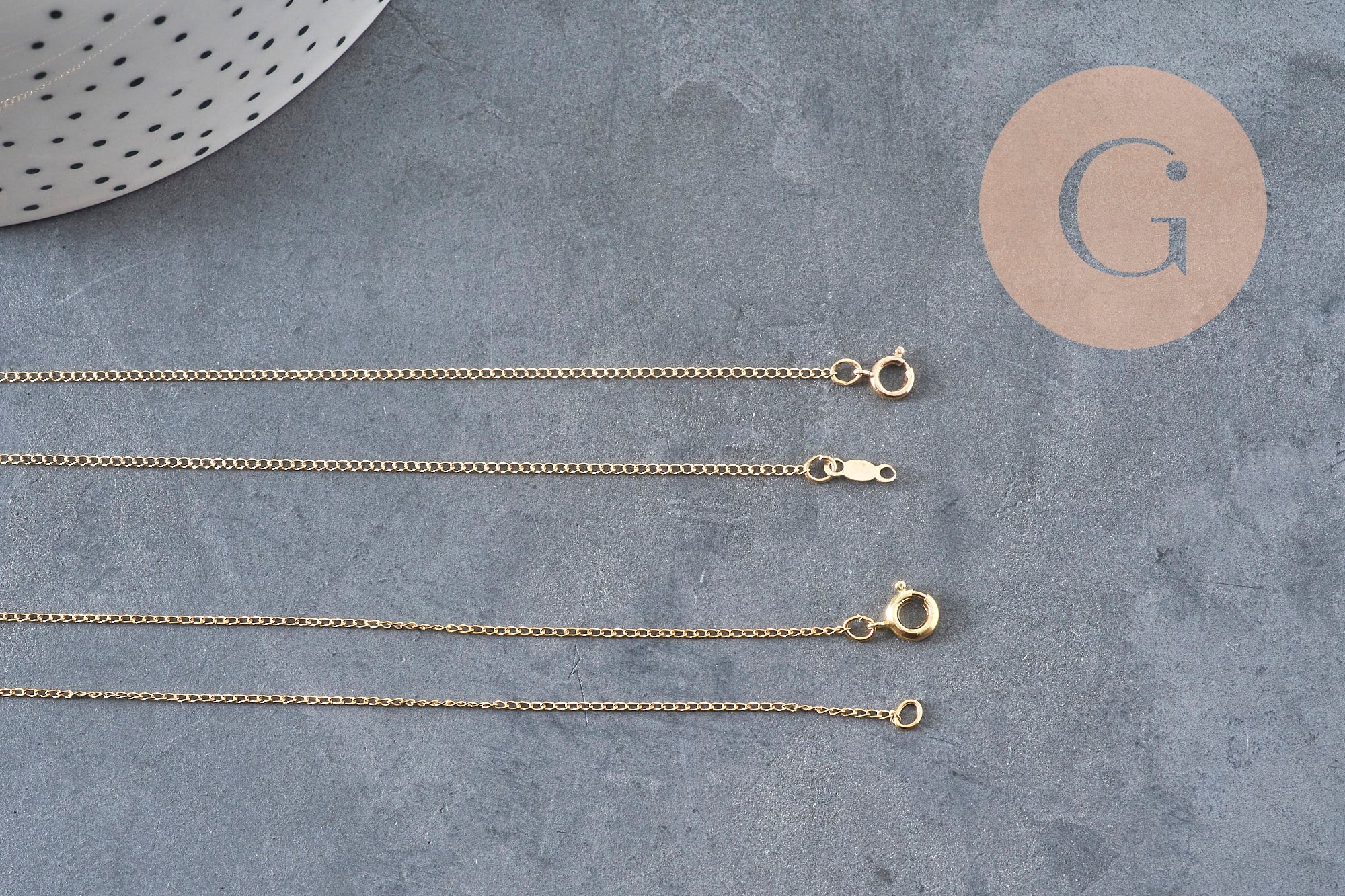 Collier chaîne fine dorée gold-filled 14K de 45.7cm avec fermoir, sur fond gris.