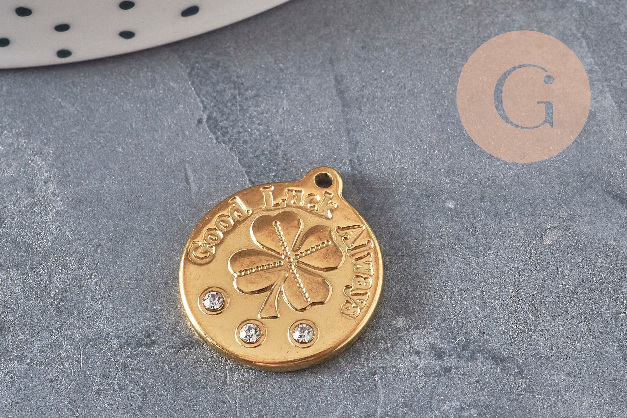 Pendentif médaille doré 20mm en acier avec trèfle à quatre feuilles, inscription Good Luck Always et trois zircons.