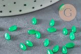 Cabochons marquise navette en jade naturel vert 6x3mm, dispersés sur une surface grise.