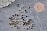 Petites perles à écraser rondelles en laiton couleur bronze, 3x2mm, sur fond gris texturé.
